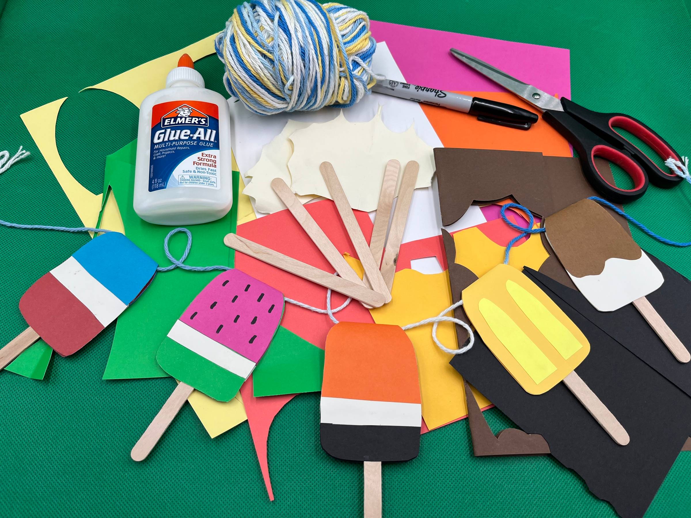 A paper popsicle garland and all the supplies you need to make your own.