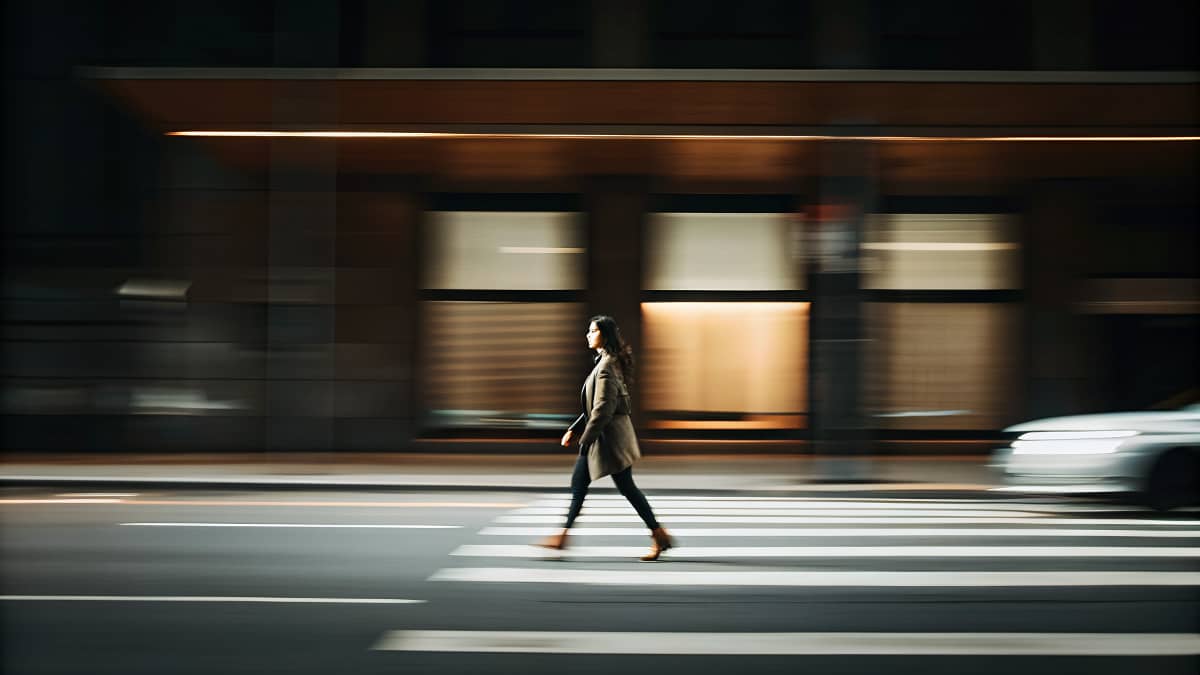 Motion-blurred city crosswalk with a person walking forward, symbolizing intentional movement, letting go, and steady progress in 2026.
