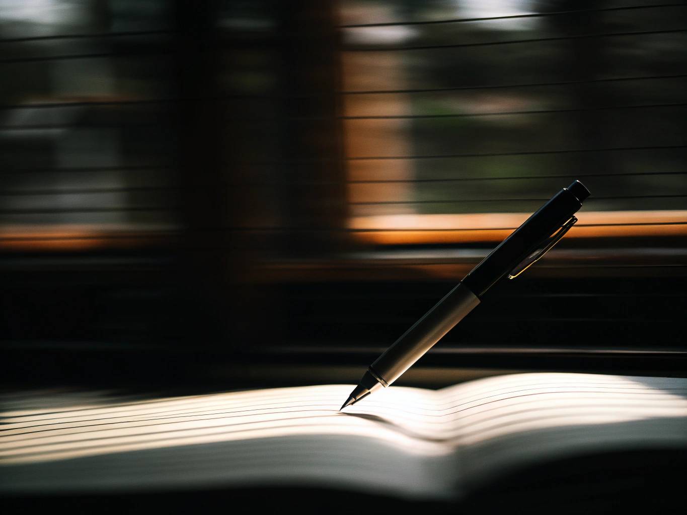 a pen writing in a notebook with a motion blurred background representing done being better than perfection