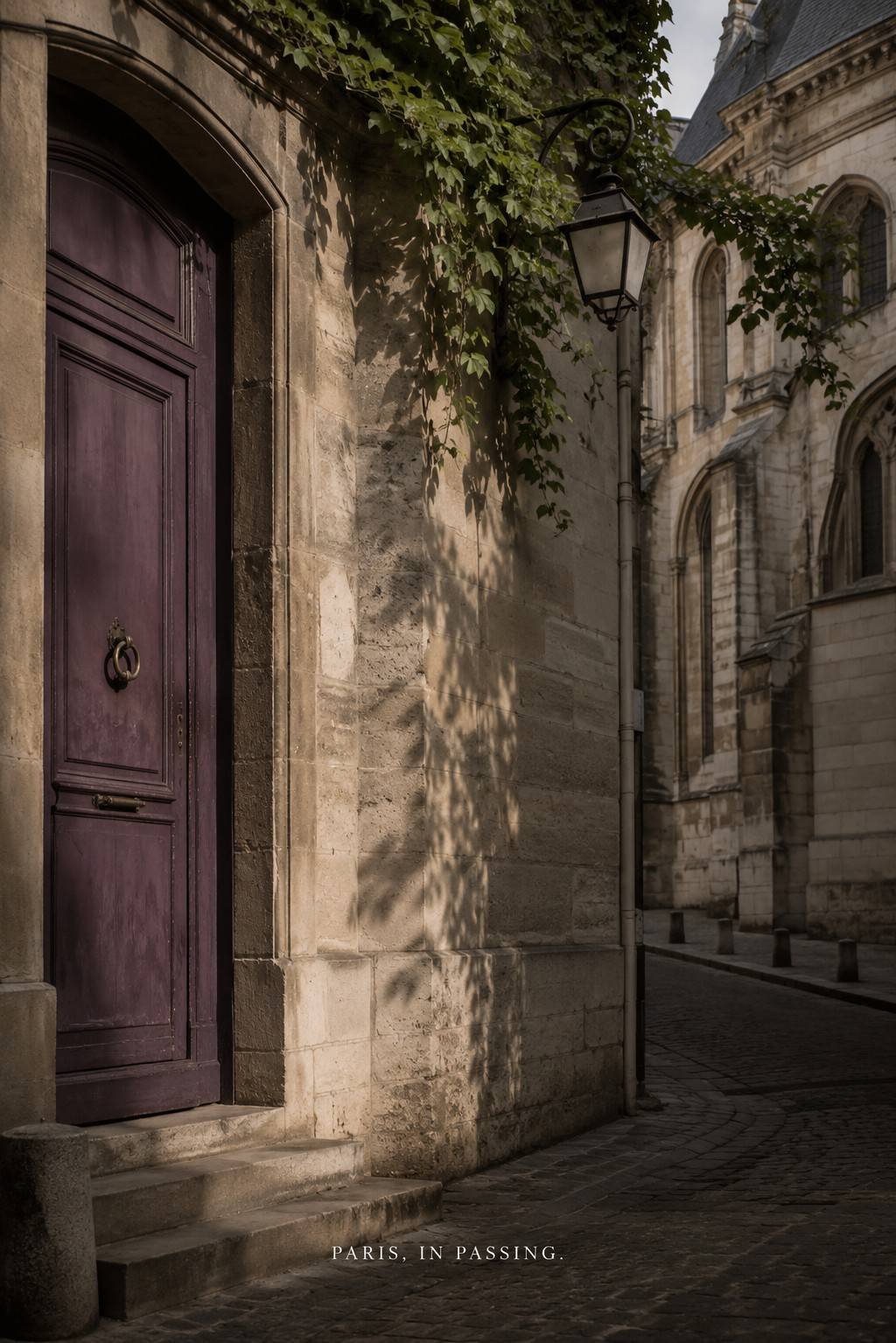 Quiet Paris street with an old wooden doorway and stone architecture.