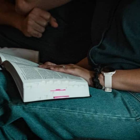 A man sitting on a chair reading a book