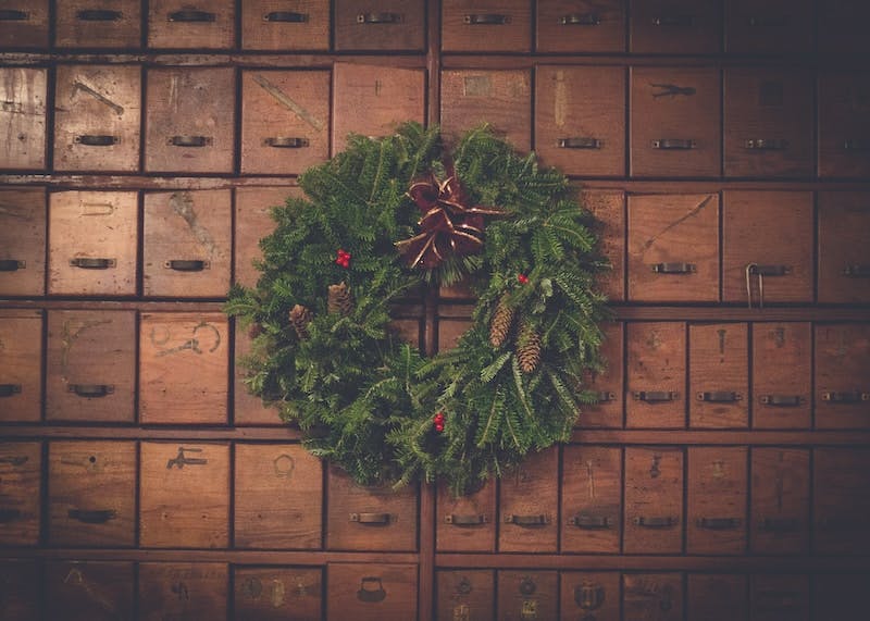 green and brown pinecone Christmas wreath on wooden drawers