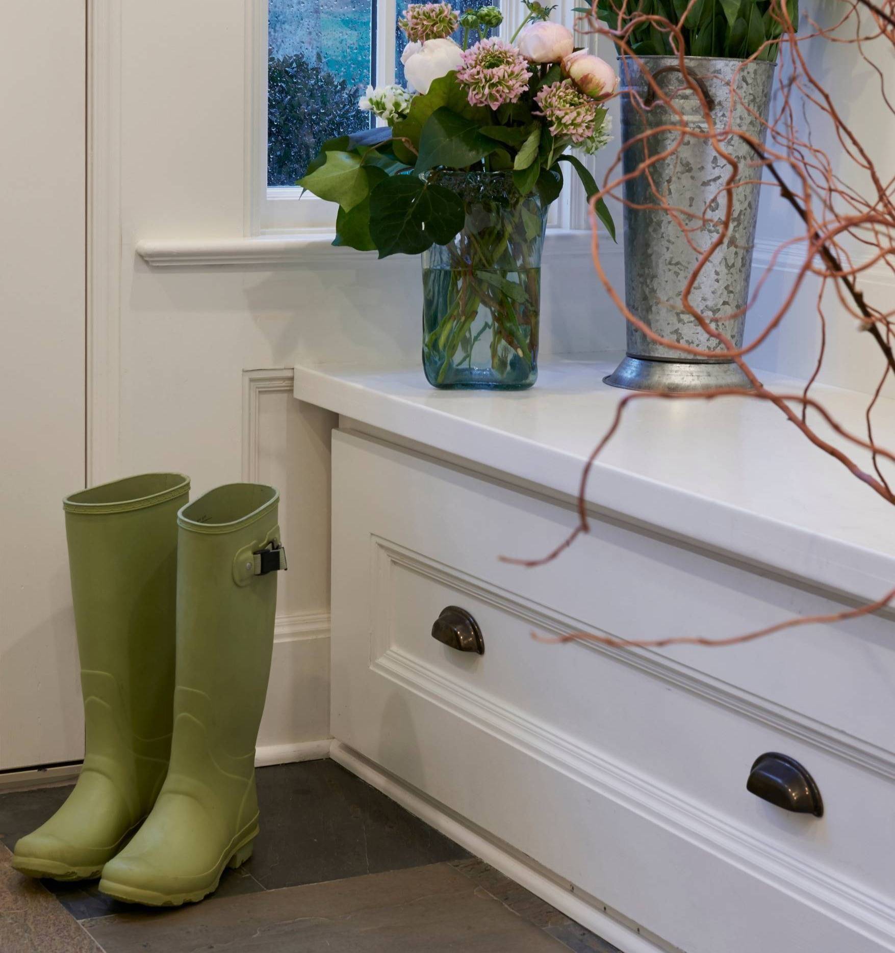 tidy entry way with flowers and rain boots