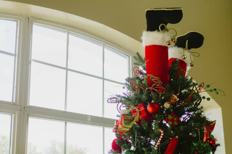 Santa's legs sticking out of a christmas tree.