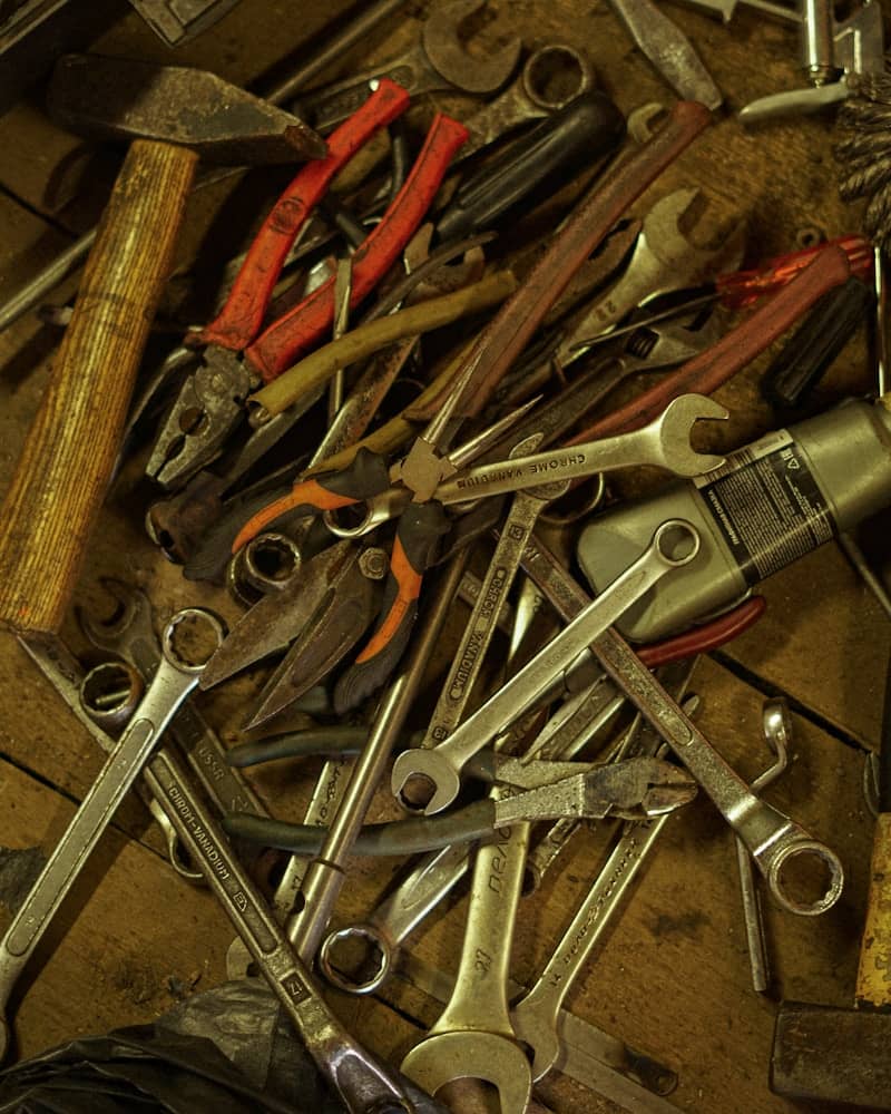 Assorted tools including wrenches, pliers, and hammer.