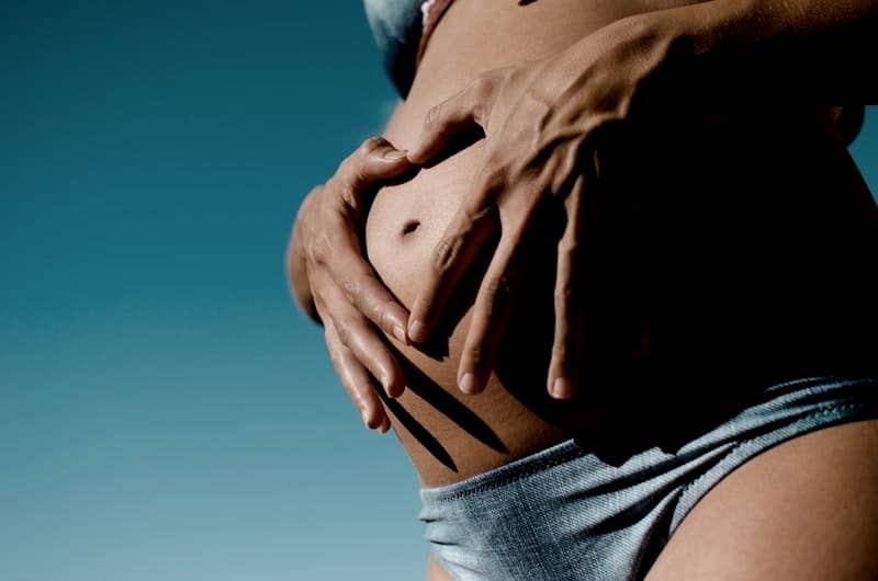 closeup photography of pregnant woman wearing blue panty