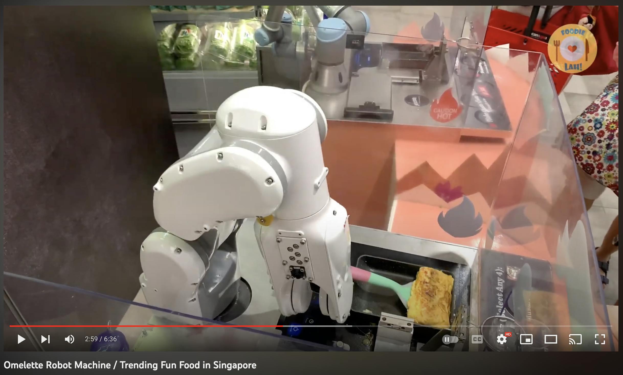 A screenshot of a YouTube video featuring a robotic arm that serves omelets.