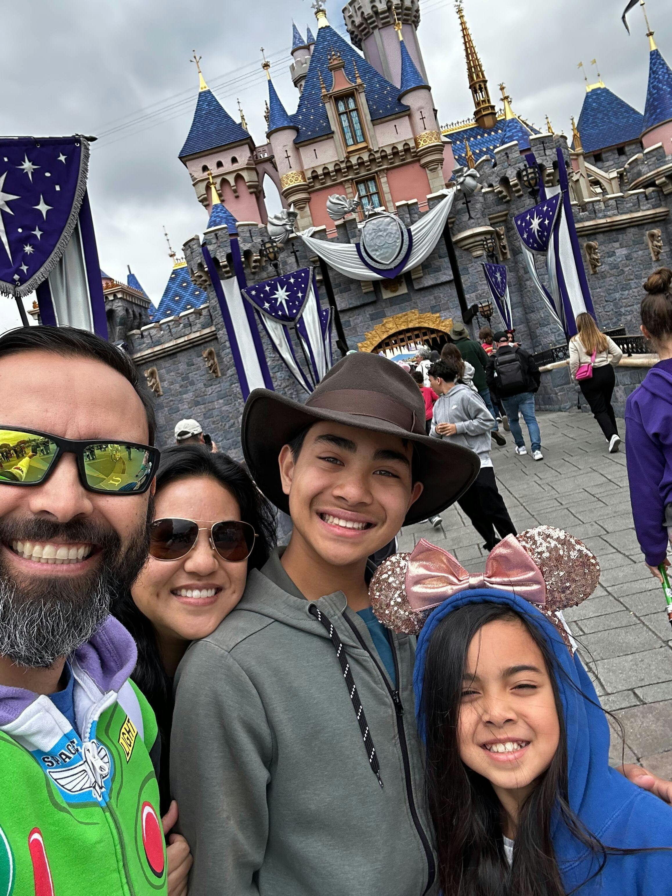 Flynn family selfie taken at Disneyland with castle in the background.