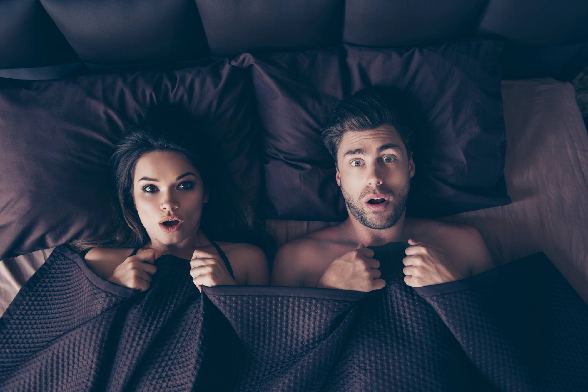 A women and a man in bed shocked.