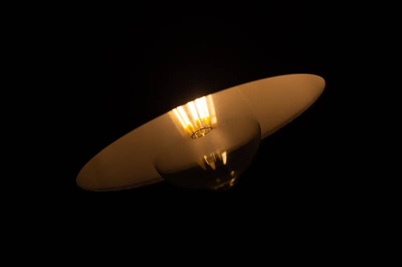 A golden cymbal illuminated against a black background