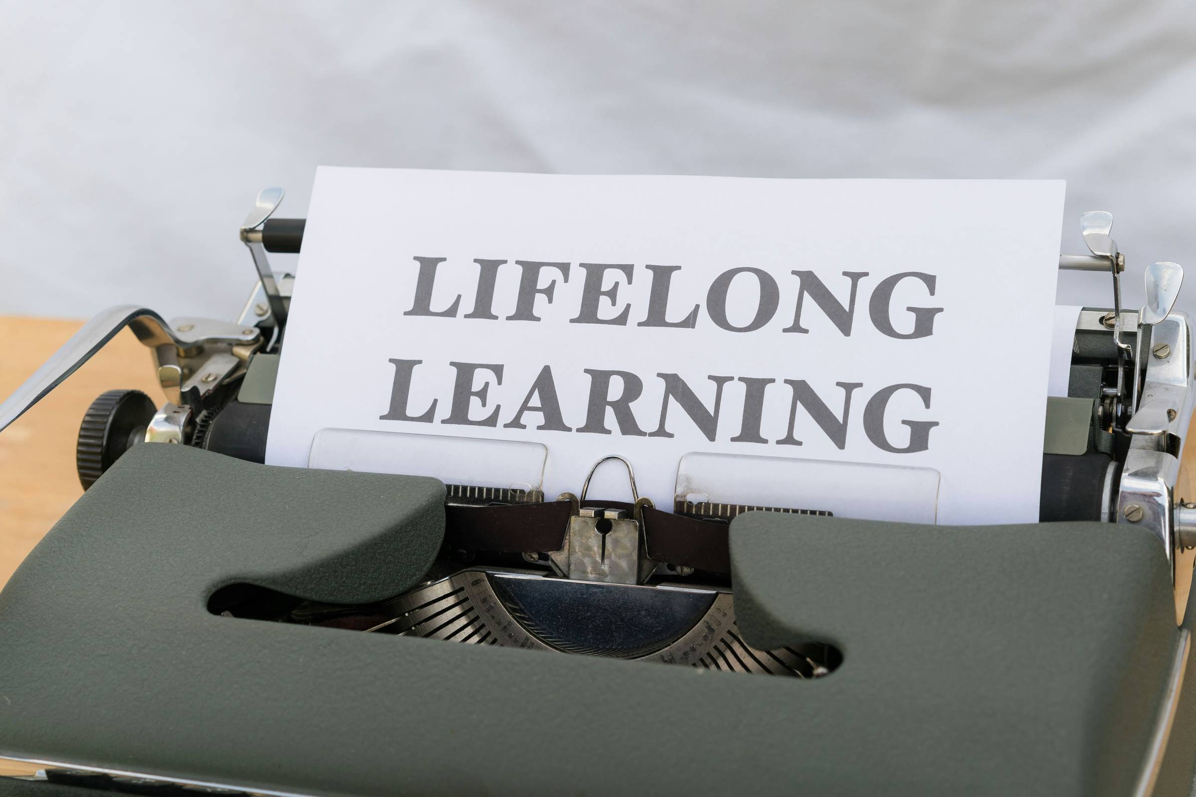 typewriter with a paper on it that reads "lifelong learning"