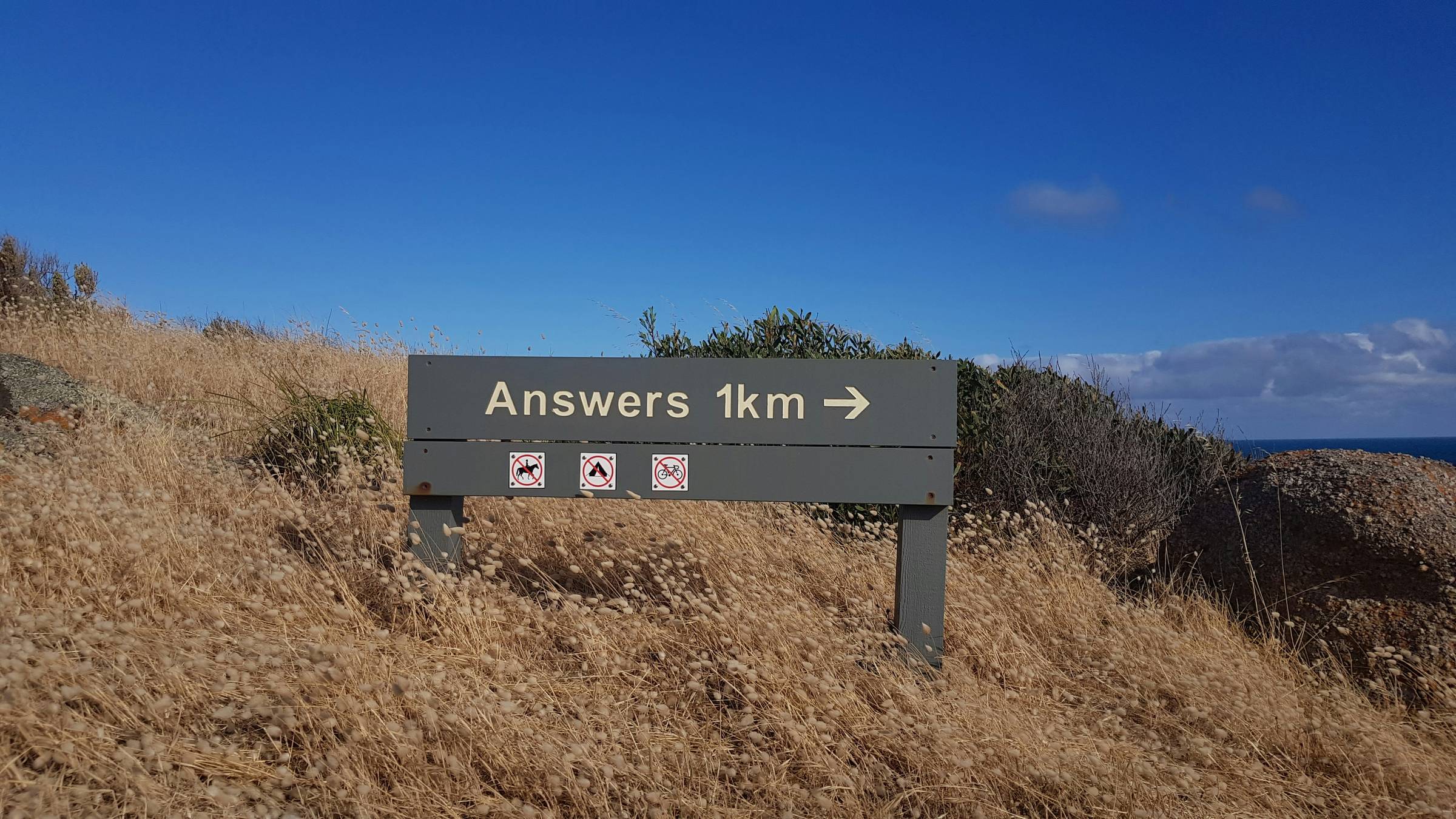 banner on a hill that reads "answers 1km"