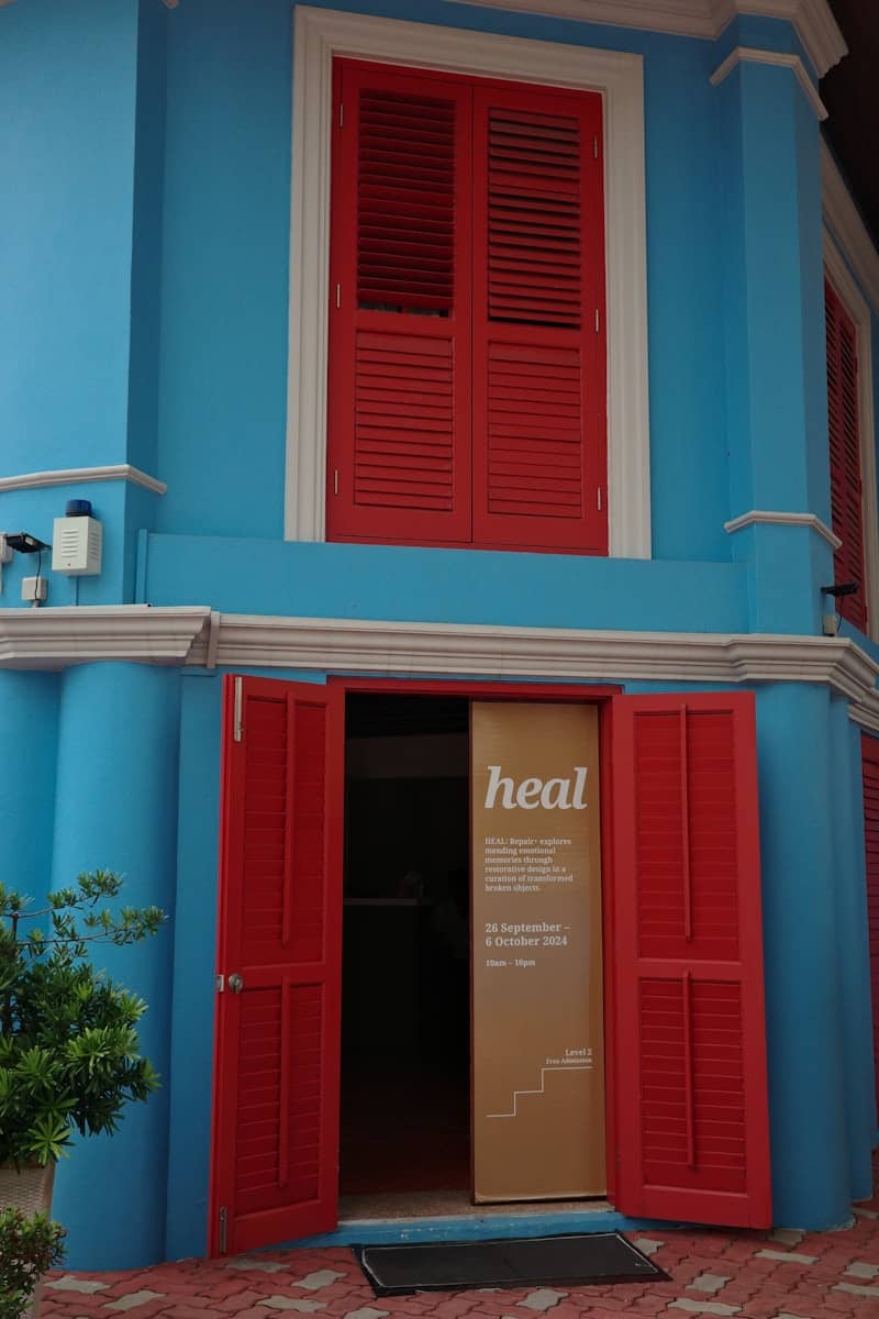 A blue building with red shutters and a door