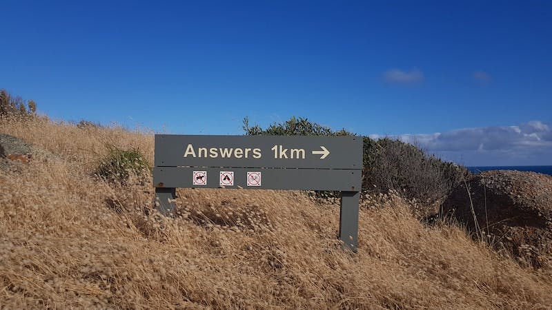 a sign that is on the side of a hill that reads "answers 1km"