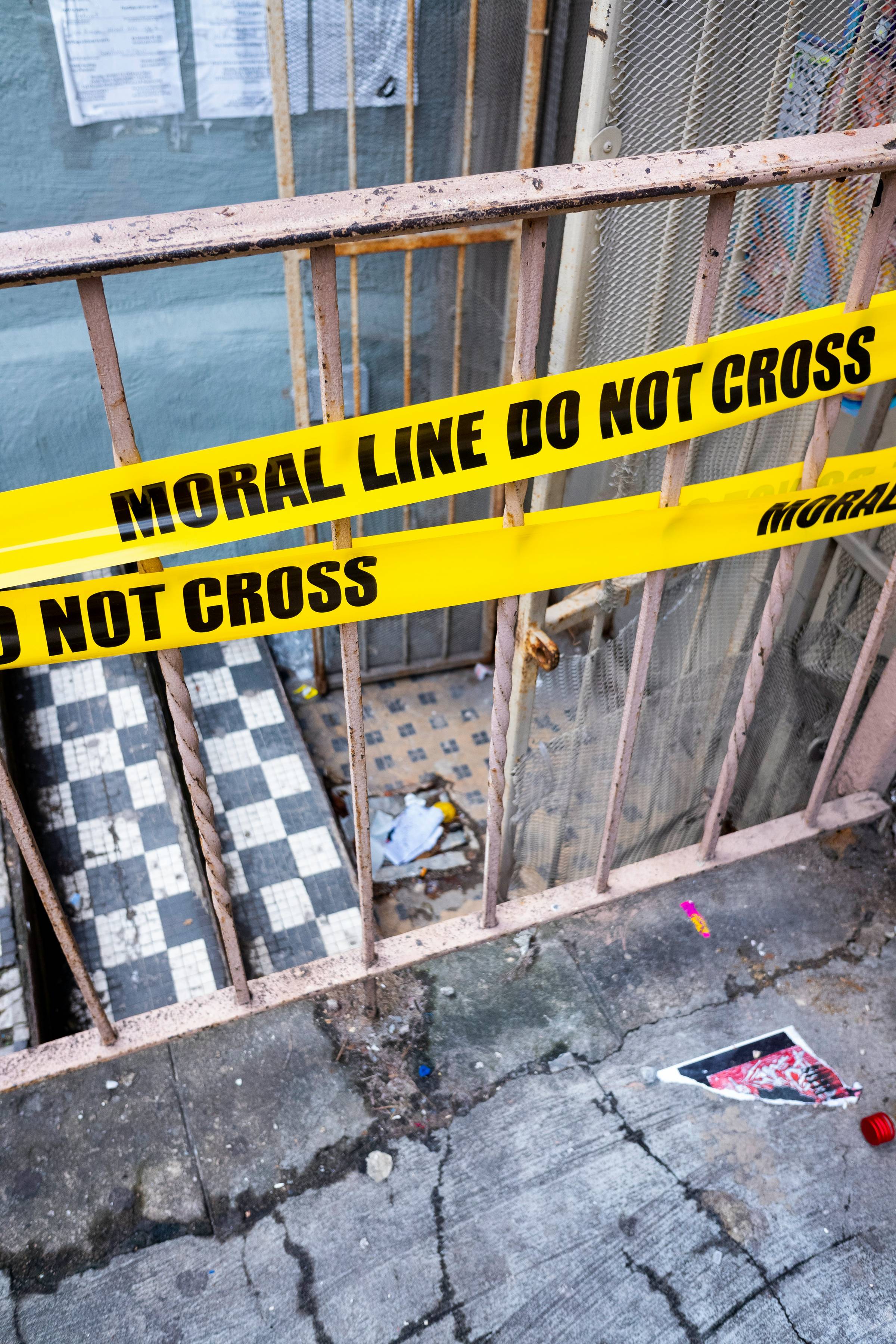 yellow tape on a balcony that reads "moral line do not cross"