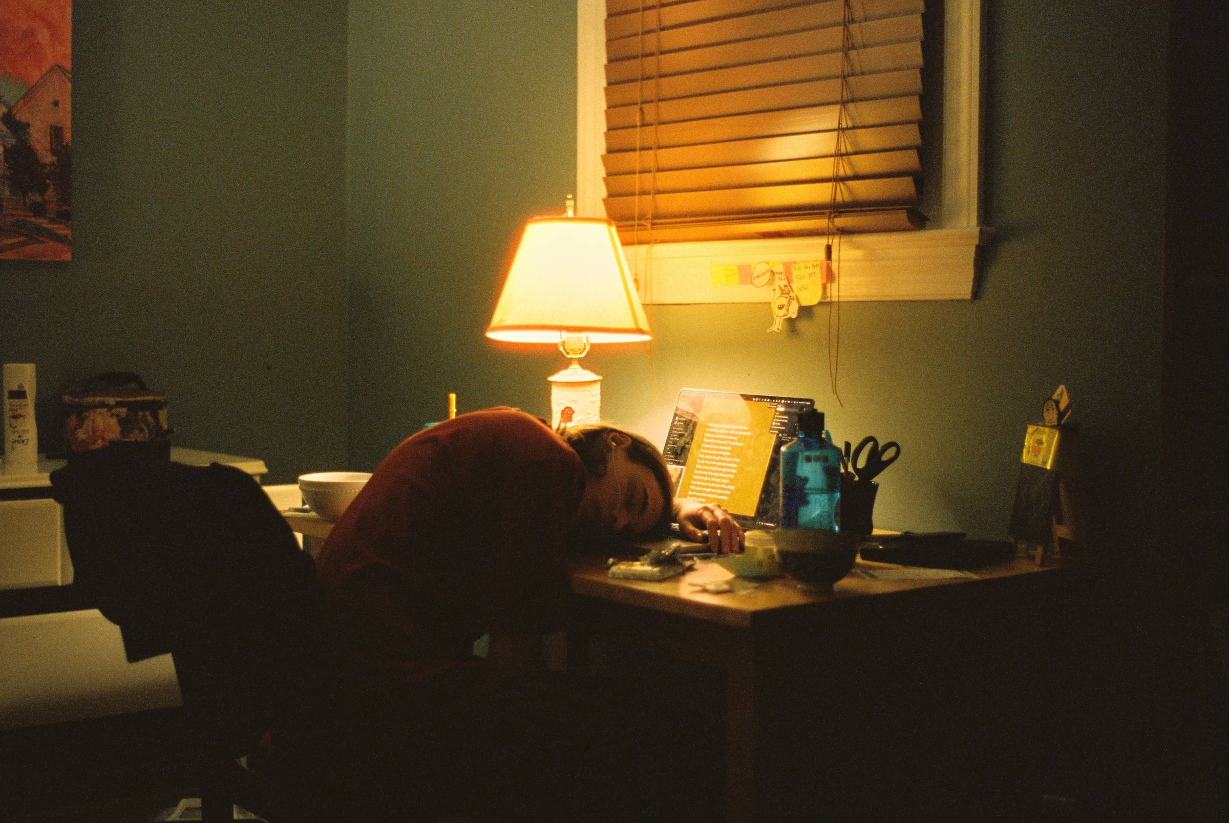 a person sitting at a desk leaning forward resting