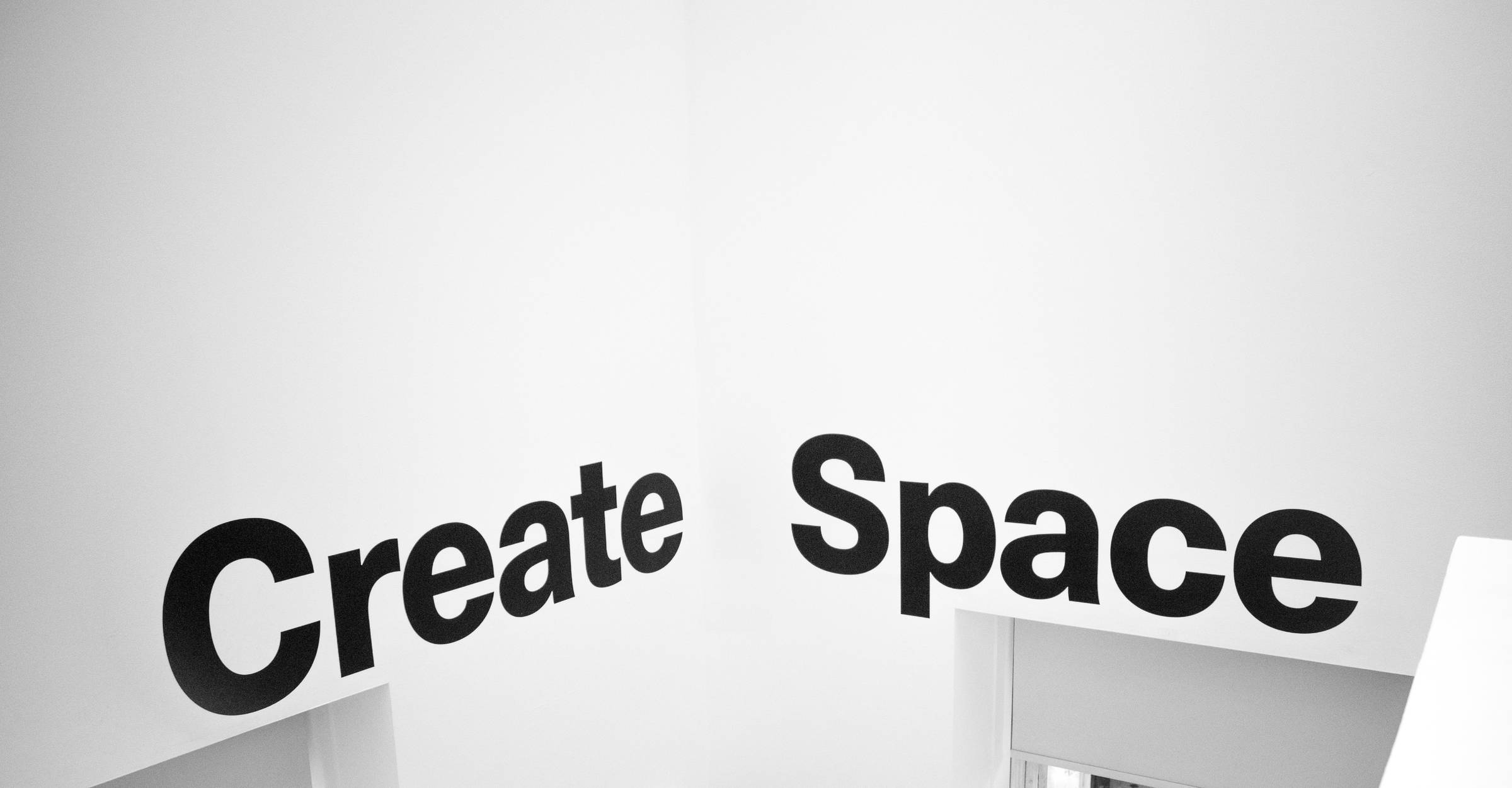 image that reads "create space" on black letters on a white wall