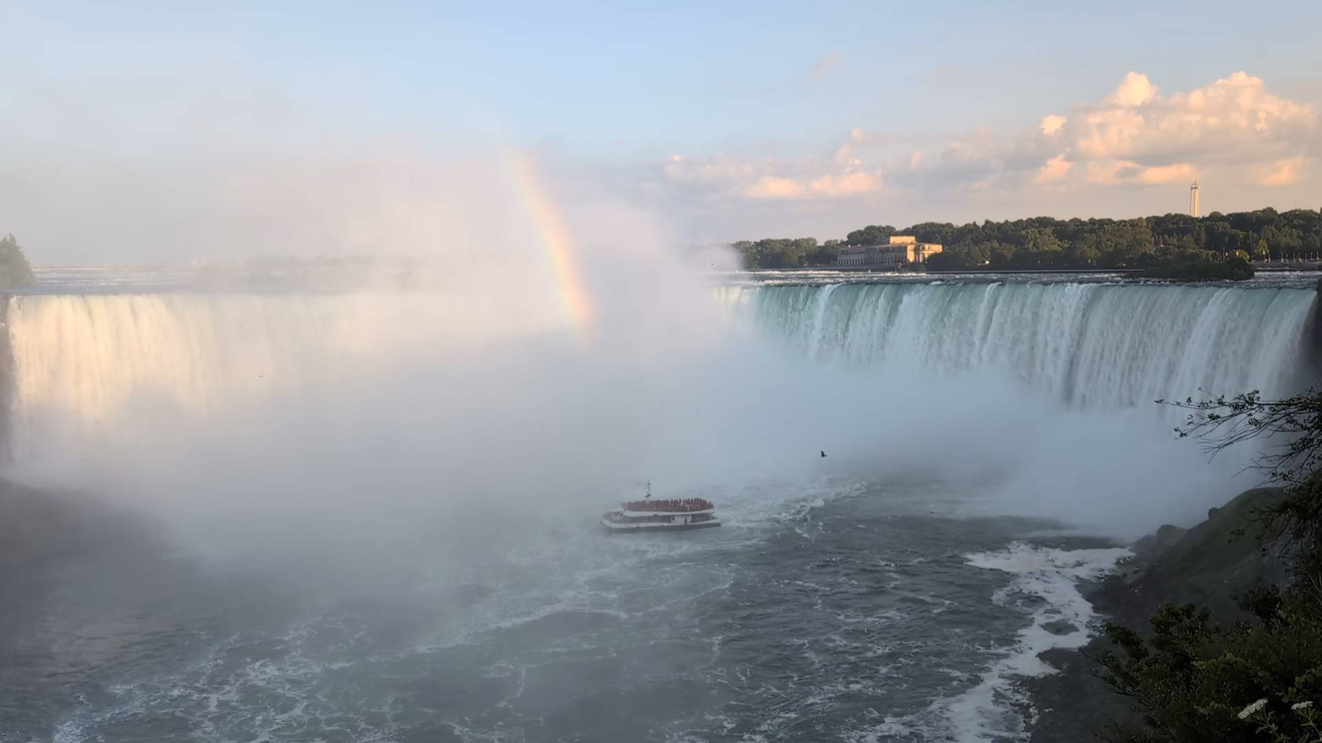 niagara falls with boat in middle and rainbow in middle