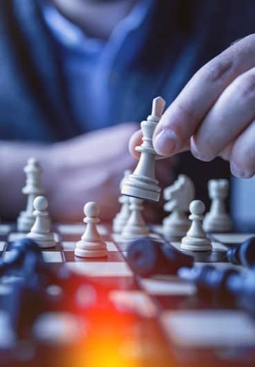 depth of field photography of man playing chess