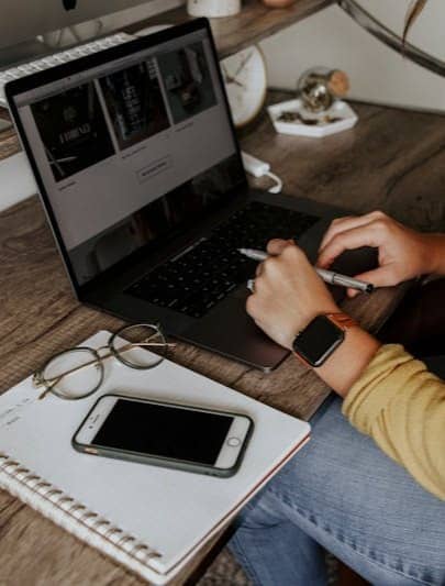 person in blue denim jeans using macbook pro