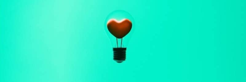 A heart-shaped light bulb floats in the air.