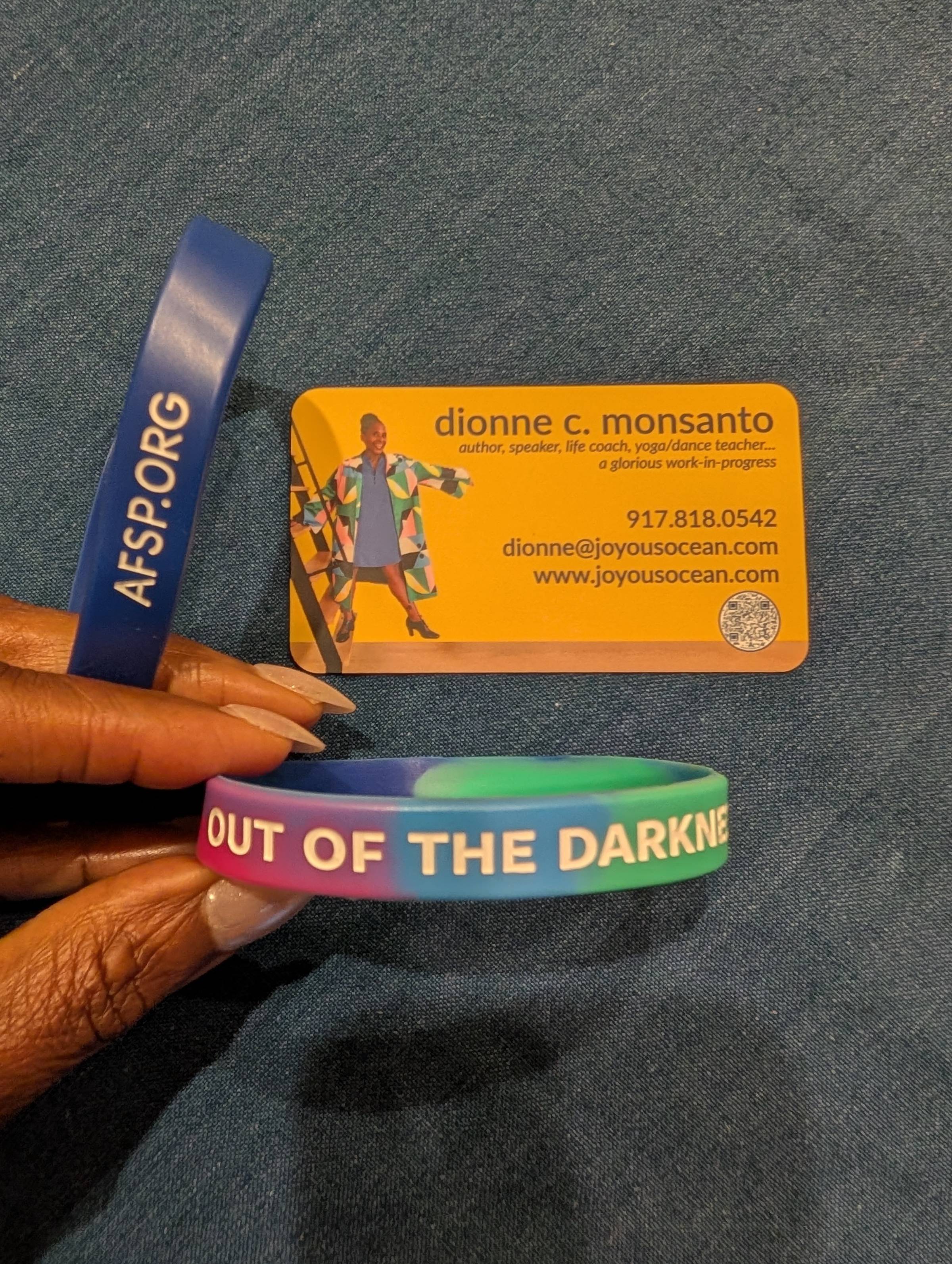 Dionne’s business card and an AFSP Out of the Darkness bracelet placed together, symbolizing the support she offered during her commute.