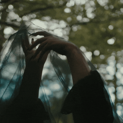 a bruje's hands moving inside sheer cloth