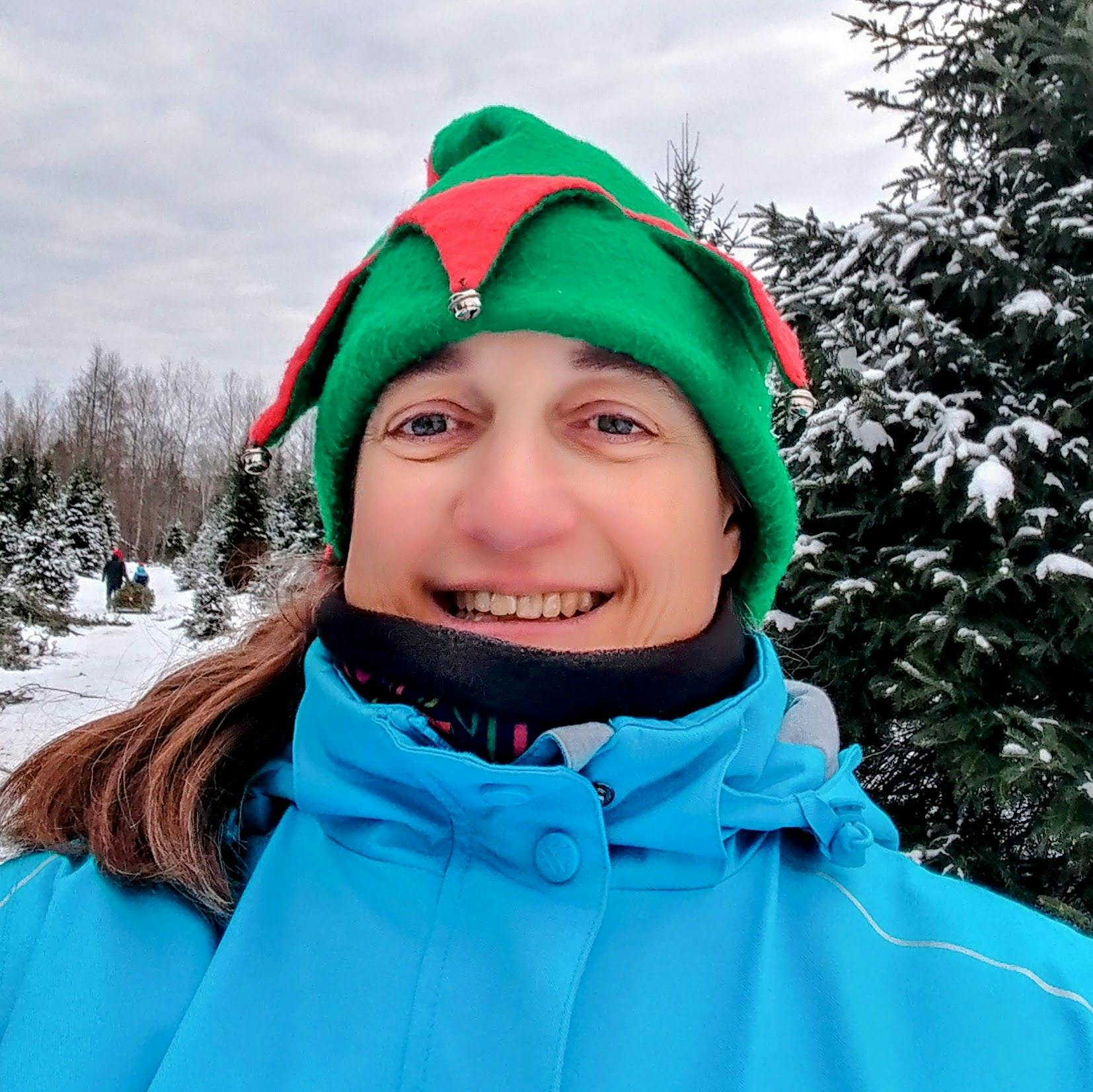 Stephie's profile picture, she's wearing a blue winter coat and a elf hat, smiling at the camera.