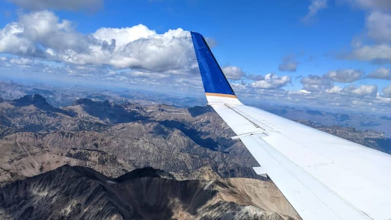 Airplane wing over the mountains