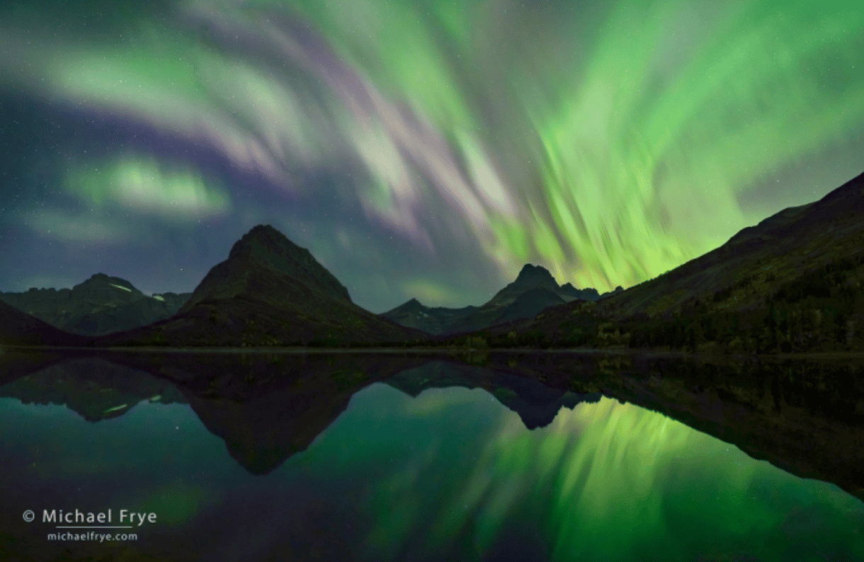 reflection of aurora in lake with mountain