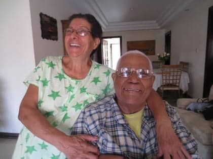 Jessica's parents in their older age hugging, smiling, and laughing. 