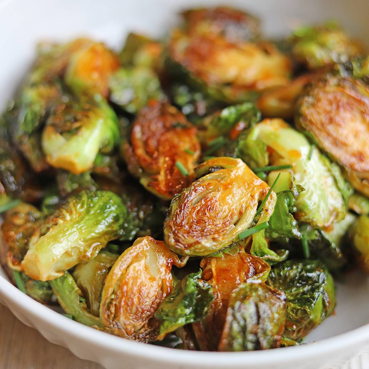 Brussels sprouts with gochujang glaze in bowl.