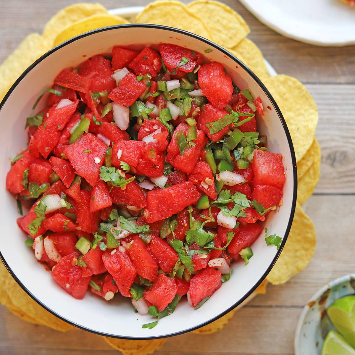 Watermelon salsa in bowl by tortilla chips.