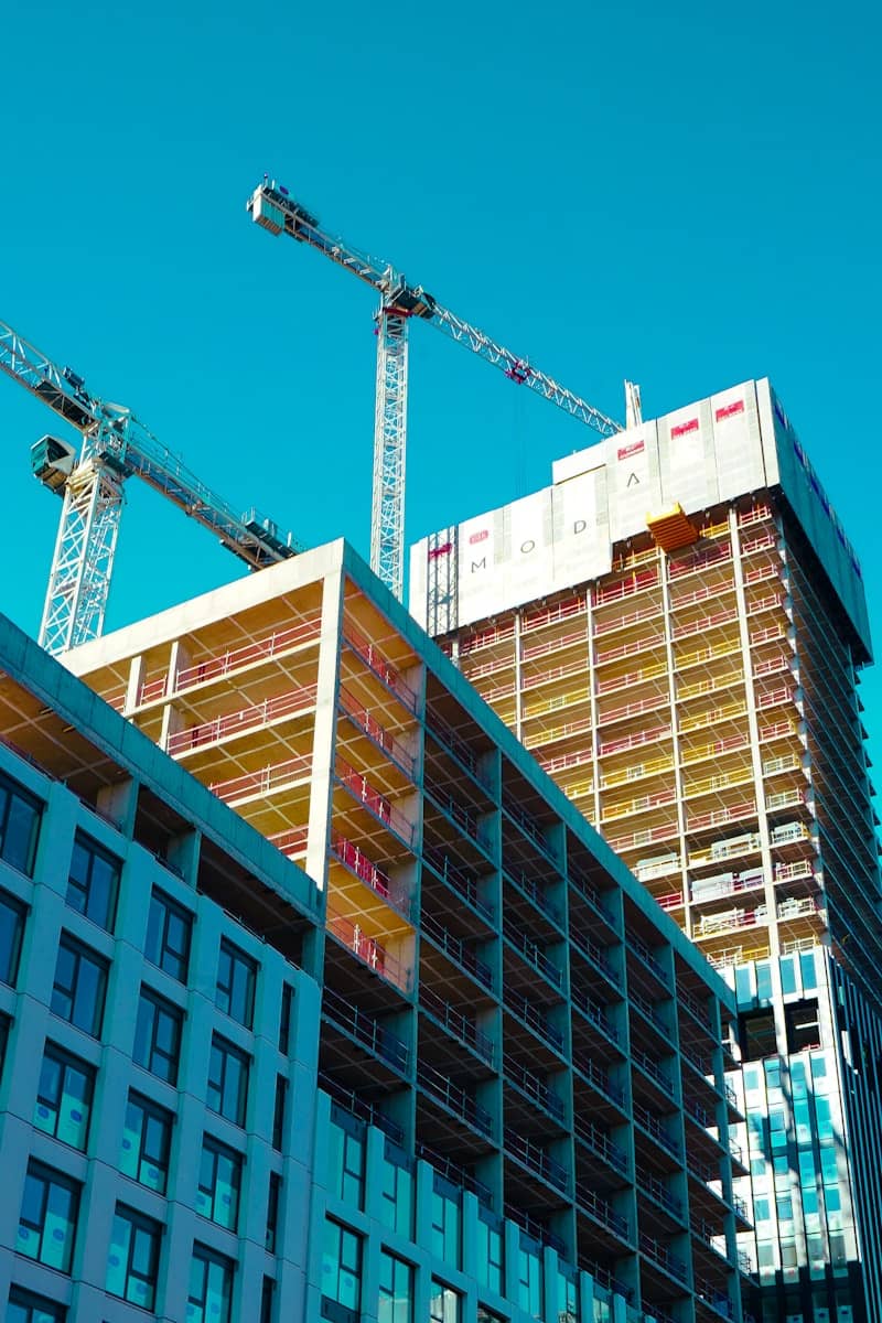 Construction cranes work on modern high-rise buildings.