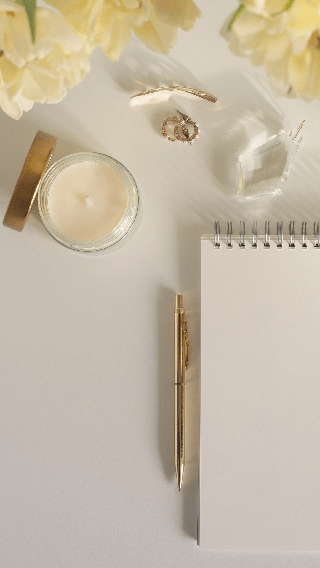 A notebook with a pen on top of it next to a bouquet of flowers