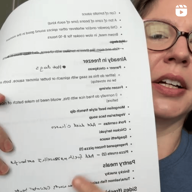 A photo of the author holding up a paper with meal plans on it to the camera.