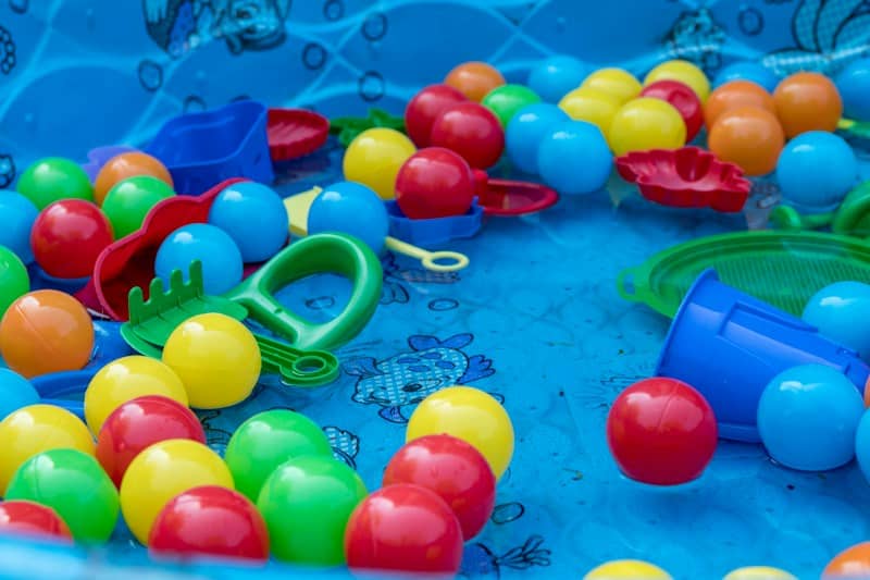 assorted color plastic balls and other toys in a kiddie pool