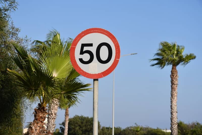 Speed limit sign with palm trees and blue sky