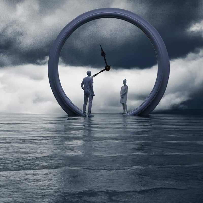 People stand inside a clock on the water.
