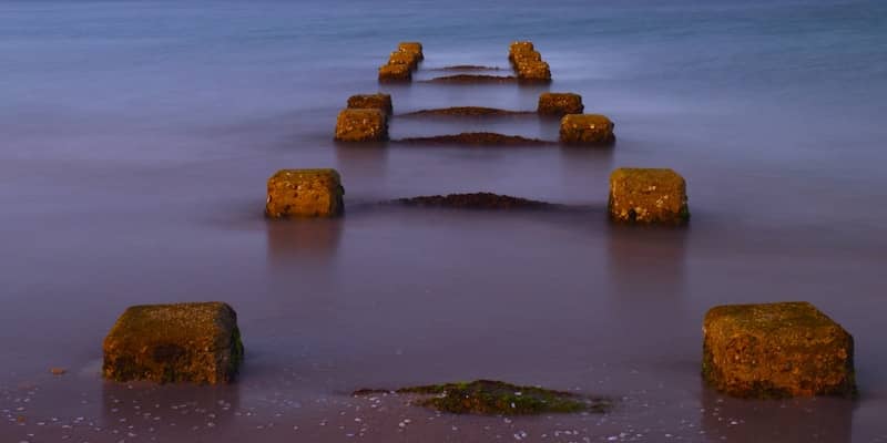 A long exposure photo of a pier in the water