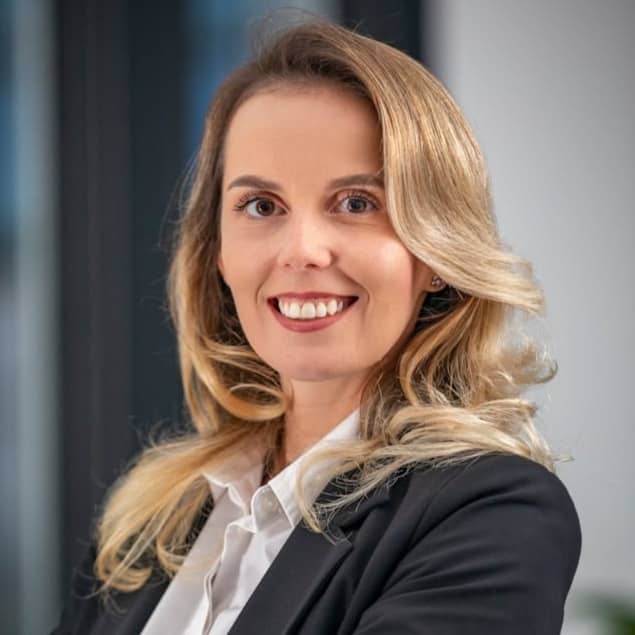 A woman in a business suit standing with her arms crossed