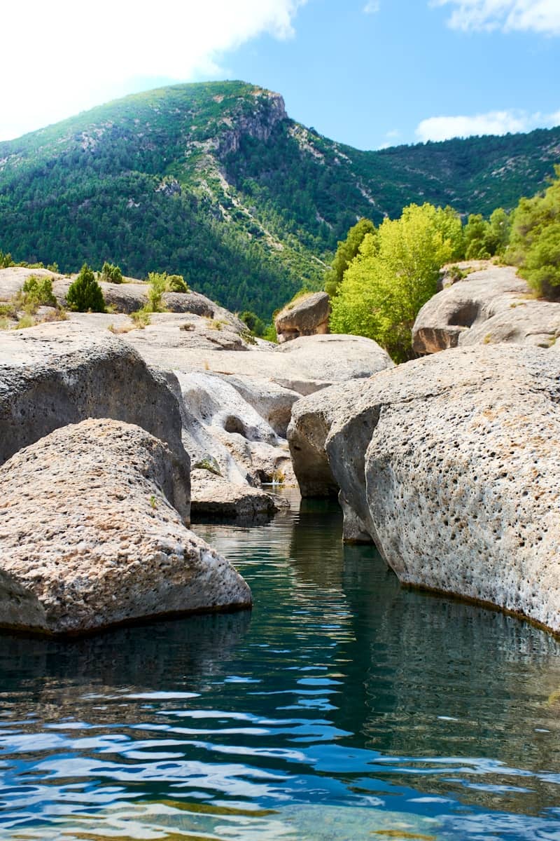 Rocky water flows towards a mountain.