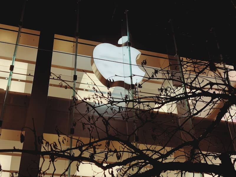 Glowing apple logo on a modern building at night