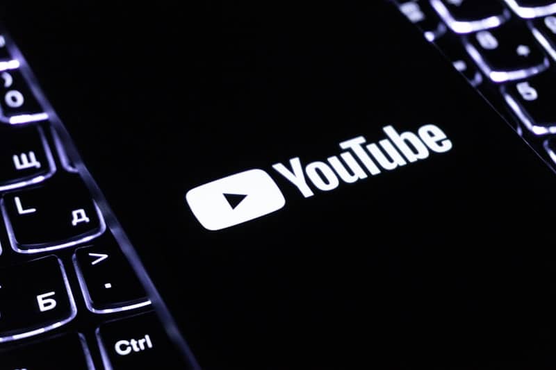 The youtube logo on a smartphone is visible.