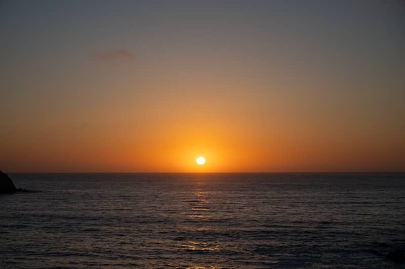 Sunset over a calm ocean with gentle waves