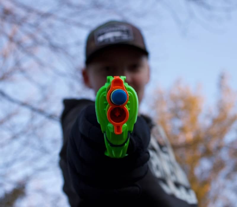 man in black and white hoodie with green and yellow round plastic toy