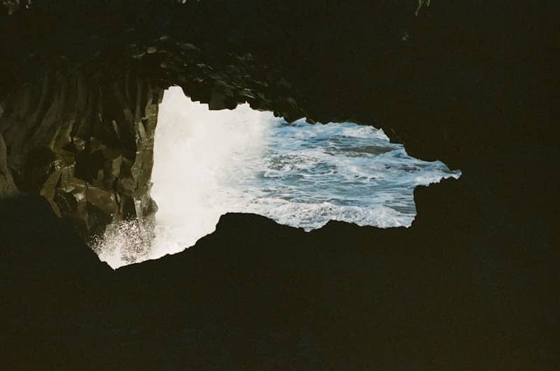 Ocean waves crashing into a dark sea cave.