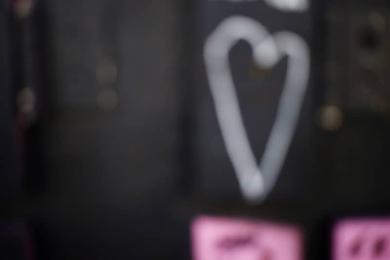 A white heart drawn on a dark, blurry background.