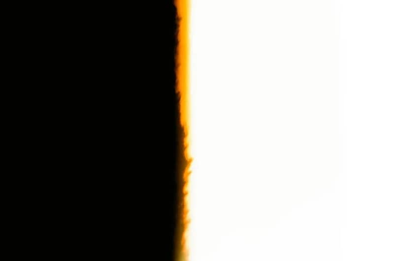 Vertical split between black and white with fiery orange edge.