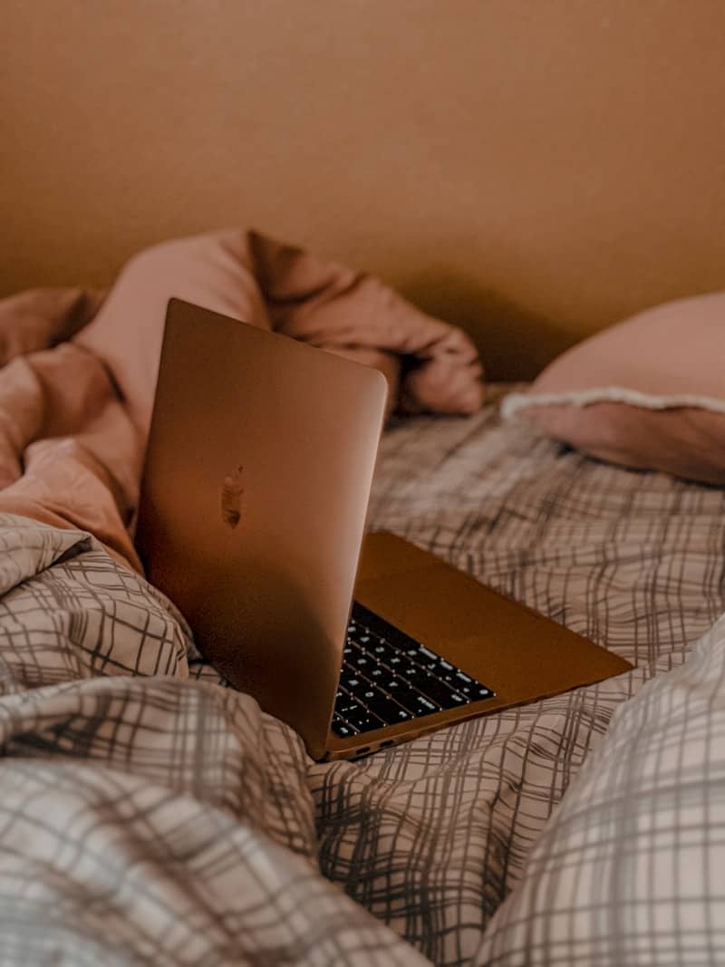 A laptop computer sitting on top of a bed